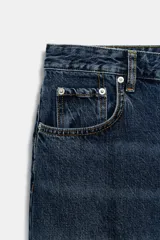 Jeans de tiro bajo y corte recto, confeccionados en denim azul con lavado clásico. Presentan cinco bolsillos, trabillas en la cintura, raya planchada frontal y bajo con vuelta marcada.