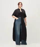 Vestido chemise midi color negro confeccionado en viscosa, de corte recto y holgado. Cuenta con cuello camisero, mangas cortas y cierre frontal con botones al tono.