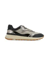 Sneaker de diseño urbano con combinación de texturas y colores, presentando paneles en cuero negro, gamuza beige y detalles metalizados en tono plateado. Cuenta con suela de goma con plataforma en color crema y base dentada.