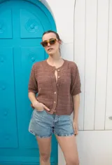 Saco tejido calado color ocre, con mangas al codo y botones de coco. Tiene grifa de cuero en la espalda.