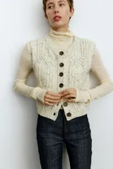 Jean de tiro alto con corte acampanado desde la rodilla, confeccionado en denim elástico de color azul oscuro. Presenta cierre frontal con botón y bolsillos delanteros insertados.