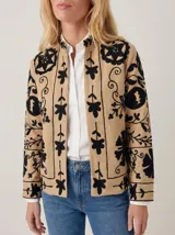 Chaqueta color arena de algodón con bordados negros de inspiración suzani, diseño abierto al frente y cuello mao.
