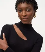 Blusa de punto acanalado color lila, con cuello alto, mangas largas y abertura en el hombro.