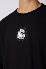 Remera oversize de corte holgado, color blanco, con cuello redondo y mangas cortas. Presenta un pequeño estampado circular en el centro del pecho con un diseño abstracto inspirado en arrecifes.