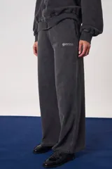 Pantalón jogger de algodón gris con efecto acid wash, corte amplio y relajado, y logo de la marca estampado en el lateral.