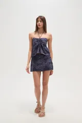 Top strapless de viscosa con estampado de azulejos en tonos azul y blanco. Presenta un diseño con cuello halter, detalle de fruncido central y un lazo decorativo en el frente.