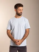 Remera básica de manga corta en color celeste claro, confeccionada en algodón, con cuello redondo y pequeño logo bordado en el pecho.