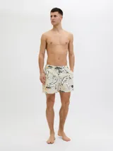 Short de baño de tiro medio con estampado botánico abstracto en tonos blanco, negro y amarillo sobre base color crema. Cuenta con cintura elástica con cordón ajustable, bolsillos laterales y bolsillo trasero.