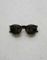 Lentes de sol Kubu modelo Tigris Olive, con montura redonda de carey y lentes polarizados color verde oscuro.