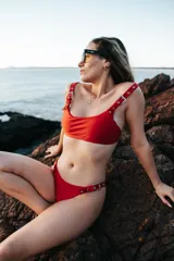 Conjunto de bikini rojo con hebillas metálicas plateadas y bombacha colaless.