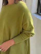 Sweater de punto color verde pistacho, con cuello redondo, mangas largas con puños ajustados y diseño holgado de corte oversize.