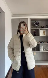 Campera puffer de corte recto y cuello alto, con cierre frontal completo y bolsillos laterales. Diseño acolchado con costuras horizontales.
