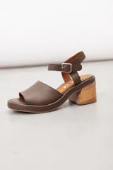 Sandalia de cuero marrón con diseño open-toe, tira ancha en el empeine, correa ajustable con hebilla en el tobillo y tacón ancho de madera.