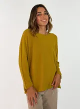 Sweater de punto color mostaza, con cuello redondo, manga larga y diseño holgado con costuras laterales visibles.