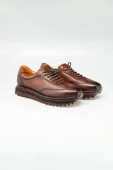Zapatillas urbanas de cuero marrón con cordones y suela de goma.