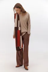 Polera de tejido de punto acanalado en color negro, con cuello alto y diseño de corte recto con largo asimétrico, más corto adelante y más largo atrás.