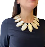 Collar corto con eslabones dorados y piezas de resina color marfil con forma de hojas. Cierre con mosquetón y largo regulable.