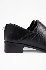Zapato tipo mocasín de cuero vacuno con textura grabada, diseño de punta fina y taco bajo cuadrado. Cuenta con cierre en la parte posterior del talón.