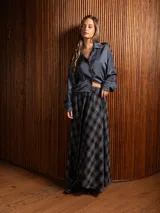 Pollera larga de corte amplio y voluminoso, con estampado de cuadros escoceses en tonos azul marino y amarillo. Presenta cintura elástica y bolsillos laterales.