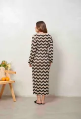 Vestido largo de lurex con diseño de patrón en zigzag en tonos tostado y marrón, escote en V con cordones para atar y mangas largas.