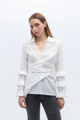Camisa blanca de algodón con diseño cruzado y mangas largas con volados.