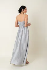 Vestido largo de satén color gris plateado, con breteles finos, escote cruzado y corte debajo del busto.