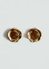 Aros de metal dorado con diseño orgánico y aplicación central de resina ámbar.