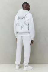 Pantalón deportivo de tejido de felpa color gris melange, con interior cepillado suave. Presenta cintura elástica con cordón de ajuste oculto, bolsillos laterales y un bolsillo trasero abierto. Las piernas terminan en puños acanalados.