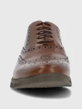 Zapato tipo oxford de cuero color marrón con diseño brogue, cordones al tono y suela de goma tipo deportiva.