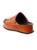 Sandalia con plataforma color naranja metalizado, con tira ancha sobre el empeine y plantilla negra.