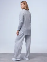 Sobrecamisa gris en tejido acanalado, con cuello con solapa, abertura central con botones y bolsillos delanteros.