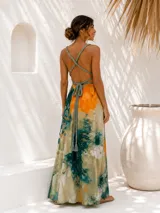 Vestido largo verde con diseño estampado tipo tie-dye y detalles dorados, de corte fluido, un solo hombro y diseño amplio.