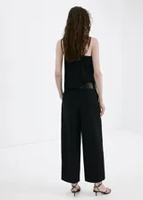 Pantalón largo de corte recto y tiro medio, confeccionado en lyocell, con trabillas en la cintura y cierre frontal oculto.