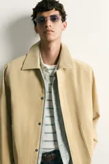 Cazadora regular fit de cuero con acabado de ante en color beige, con cuello solapa, bolsillos de plastrón en la cadera y cierre frontal de cremallera oculta por solapa con botones a presión.
