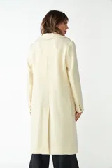 Tapado largo color beige confeccionado en lana, con cuello con solapa, manga larga, forrado, con bolsillos y cierre frontal con botones. Tela 100% lana fina sin teñir, diseñada exclusivamente por Don Baez. Hecho 100% en Uruguay.