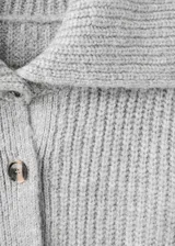 Cardigan de punto gris con cuello camisero, cierre frontal de botones y mangas largas.