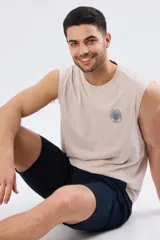 Musculosa beige jaspeado de corte clásico, con cuello redondo y diseño sin mangas. Presenta un pequeño estampado circular en el pecho con temática costera y la inscripción 'Paradise Bound'.