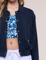 Camperita bomber de lyocell con textura suave, color azul marino, cuello camisero, cierre frontal con botones a presión, bolsillos laterales con solapa, mangas largas con puños elásticos y pretina fruncida en el ruedo.