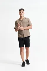 Camisa de manga corta color crema con textura, cuello clásico y calce regular.