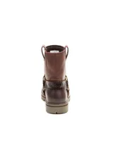 Bota de cuero color marrón con diseño tipo arnés, con detalle de correa con textura reptil y herrajes metálicos. Cuenta con suela de goma con tacos y construcción robusta.