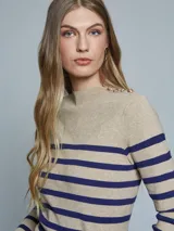 Sweater de punto a rayas horizontales en color beige y azul marino, con cuello alto y detalle de botones dorados en el hombro.