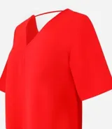 Blusa Cortelle de corte holgado confeccionada en crepé, con escote en V delantero y trasero, y mangas cortas. Presenta una tira decorativa entre los hombros en la espalda.