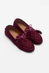 Mocasín de gamuza color bordó con detalle de flecos, cordones y tachas metálicas en la parte superior.