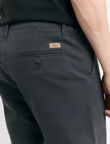 Pantalón de vestir marrón, de corte recto, con bolsillos laterales y traseros. Se ajusta a la cintura con cinturón de cuero marrón.