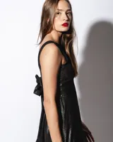 Vestido midi color salmón de tela sedosa, con cuello bote y espalda descubierta con moño.