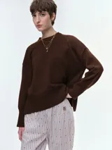 Buzo de tejido de punto en color marrón chocolate, con diseño oversize, cuello redondo, hombros caídos y puños acanalados.