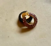 Set de tres aros trepadores con brillos, uno en tono bronce con piedras negras, uno dorado con piedras transparentes y uno plateado con piedras transparentes.