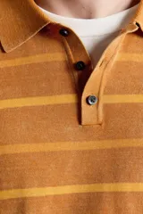 Polo de punto de algodón con diseño a rayas horizontales en tonos tostado y amarillo, cuello solapa y cierre frontal parcial con tres botones. Presenta mangas largas y efecto lavado.
