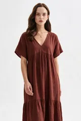 Vestido midi marrón de corte holgado, con escote en V, mangas cortas y detalle de volados fruncidos en el pecho y en el ruedo.