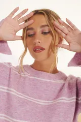 Sweater lila con rayas horizontales color crudo, de corte holgado y cuello redondo.